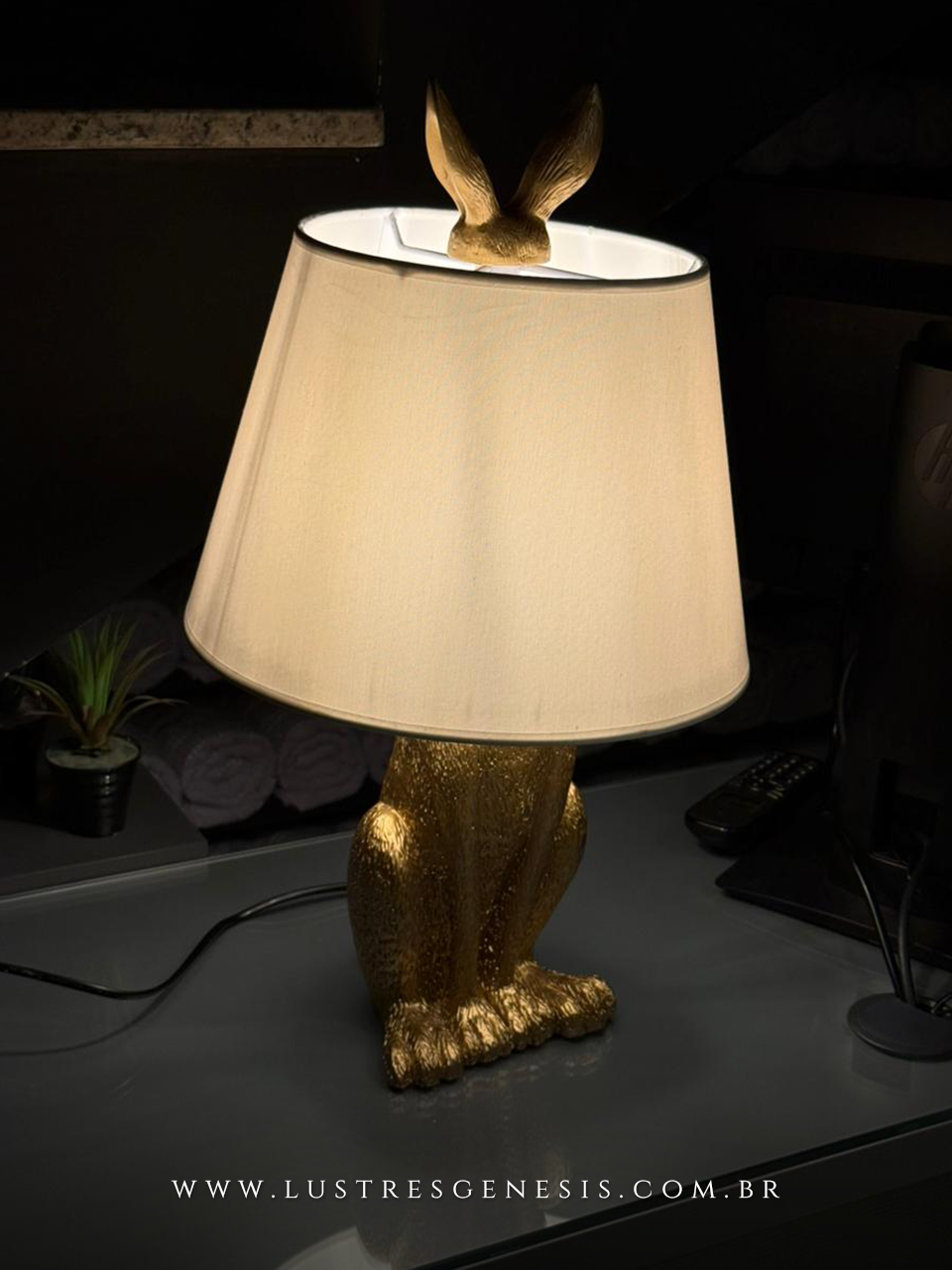 Lumin&aacute;ria de mesa abajur com base dourada em formato de coelho e c&uacute;pula bege, ideal para quartos, escrit&oacute;rios e escrivaninhas.